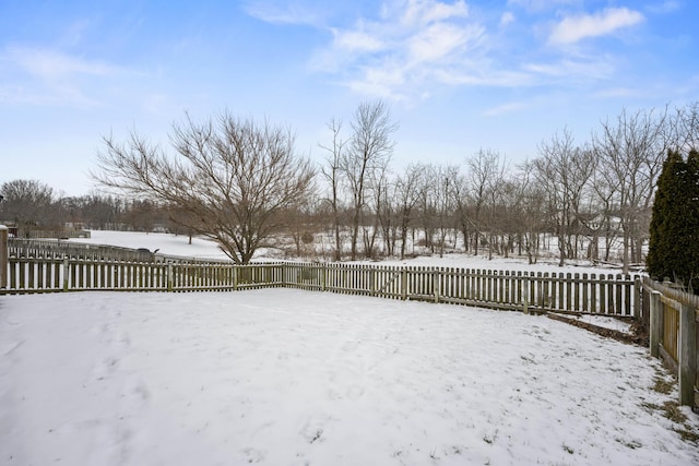 snowy yard with a fenced backyard