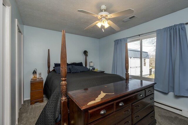 carpeted bedroom featuring a baseboard heating unit, a textured ceiling, and ceiling fan