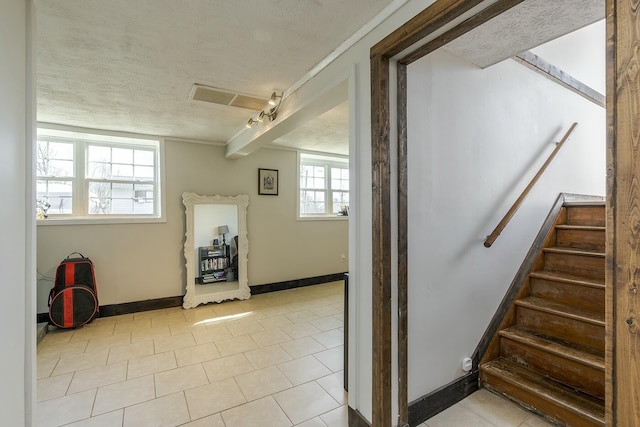 staircase with a textured ceiling