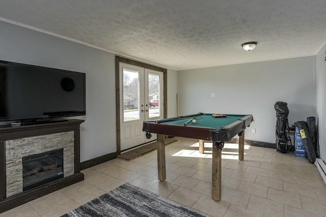 rec room with light tile patterned floors, a fireplace, a textured ceiling, pool table, and french doors