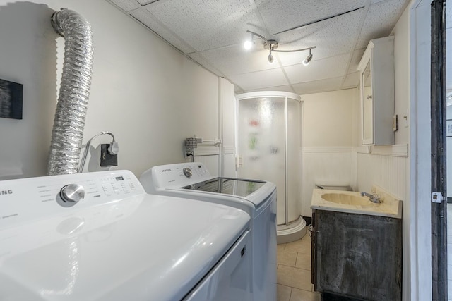 washroom featuring separate washer and dryer, sink, and light tile patterned floors