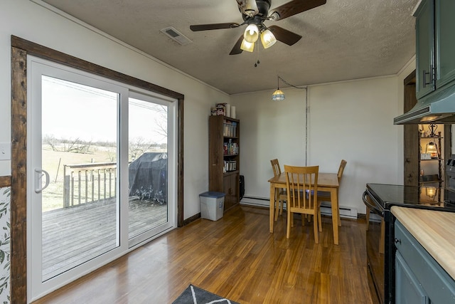 dining space featuring dark wood-type flooring, ceiling fan, a baseboard radiator, and a textured ceiling