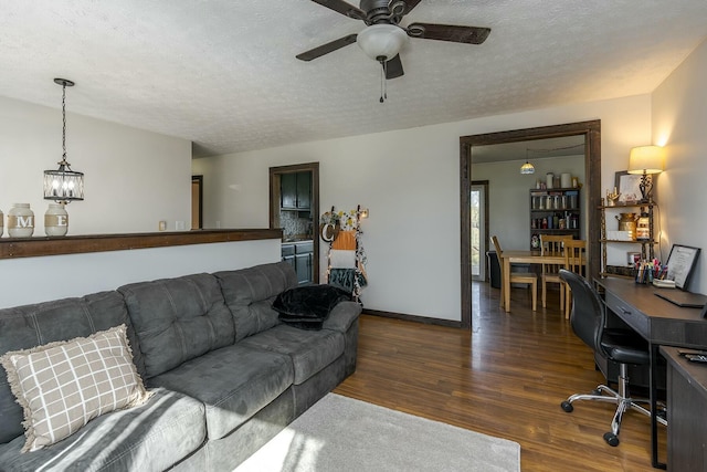 living room with dark hardwood / wood-style flooring, ceiling fan, and a textured ceiling