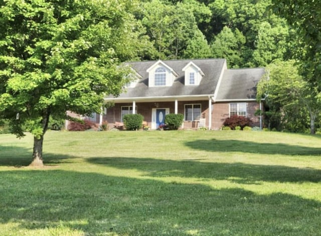 cape cod home featuring a front lawn