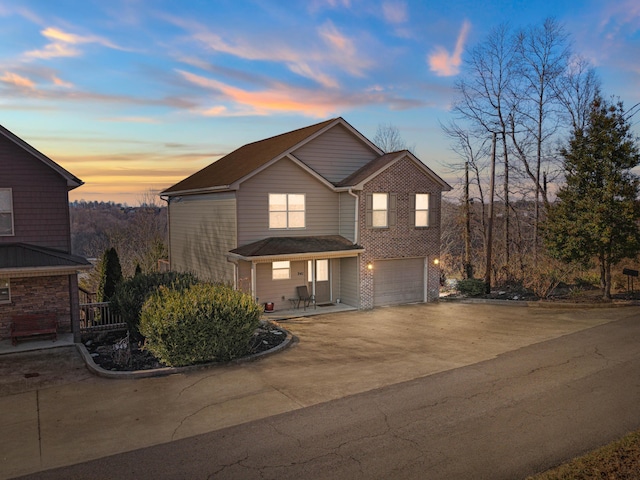 traditional home with concrete driveway, brick siding, and an attached garage