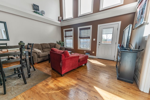 living room with a high ceiling and wood finished floors