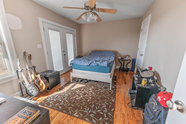 bedroom featuring dark wood-style floors, multiple windows, ceiling fan, and baseboards