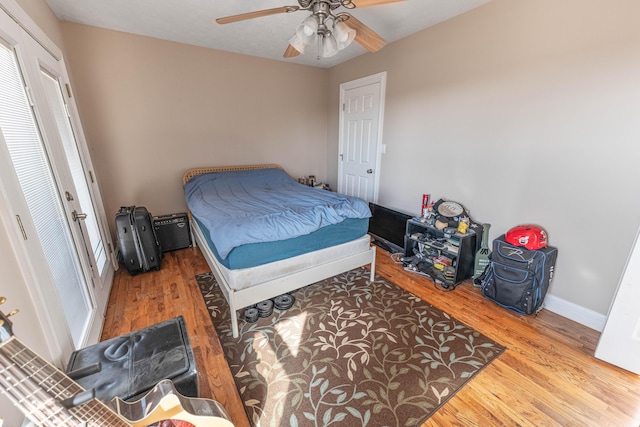 bedroom with wood finished floors, a ceiling fan, and baseboards