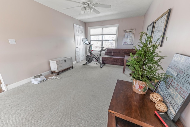 carpeted living room with ceiling fan and baseboards