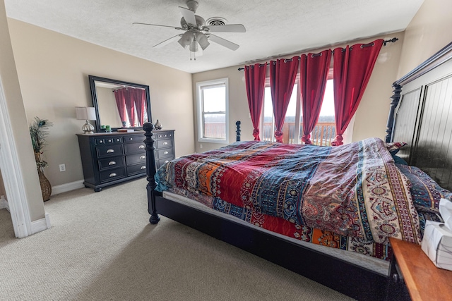 bedroom with a textured ceiling, ceiling fan, light carpet, and baseboards