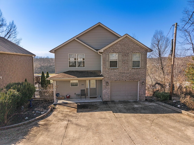 traditional home with driveway, an attached garage, and brick siding