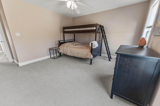 bedroom featuring a ceiling fan, light colored carpet, and baseboards