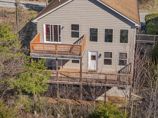 rear view of house with a balcony and a wooden deck