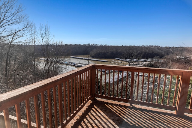 deck with a water view and a view of trees