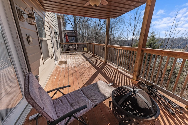 deck with a ceiling fan and an outdoor fire pit