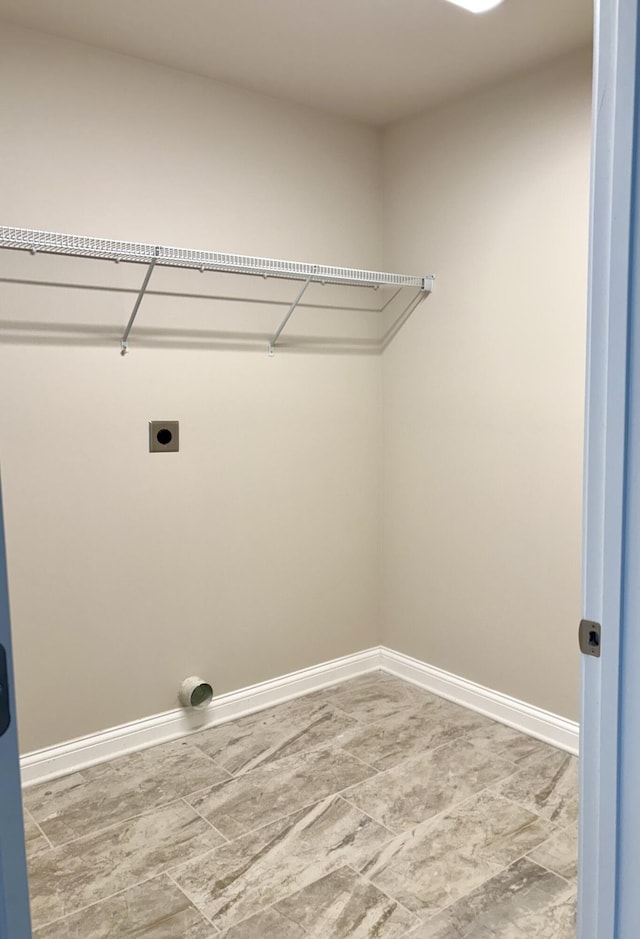 clothes washing area with electric dryer hookup, baseboards, and laundry area