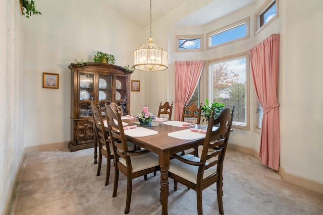 dining space with a chandelier, a towering ceiling, and light colored carpet