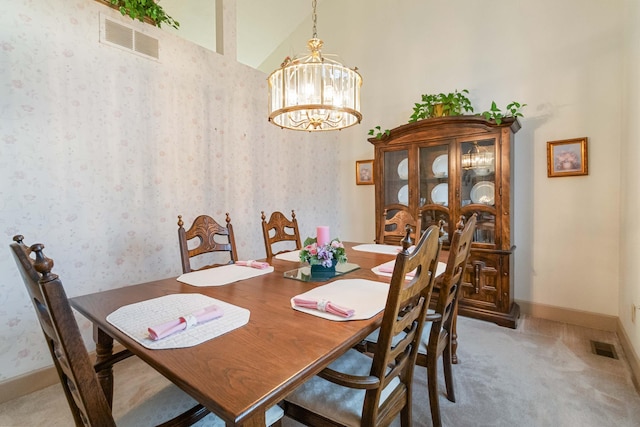 dining space with a high ceiling, a chandelier, and carpet floors