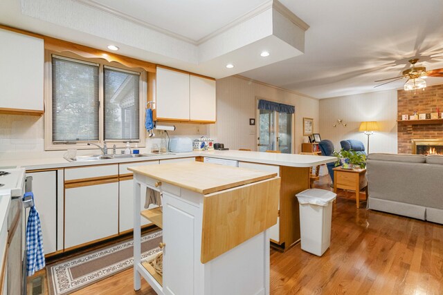 kitchen with a kitchen island, sink, white cabinetry, and a breakfast bar