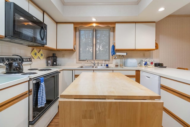 kitchen featuring white appliances, sink, a kitchen island, and white cabinets