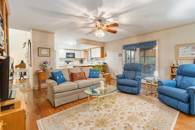 living room featuring light wood-type flooring, crown molding, and ceiling fan