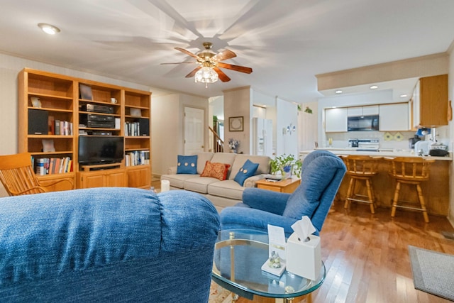 living room with ceiling fan and light wood-type flooring