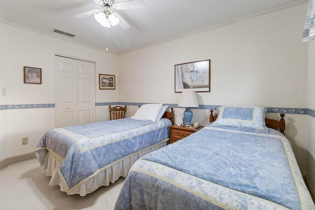 carpeted bedroom with a closet, ceiling fan, and ornamental molding