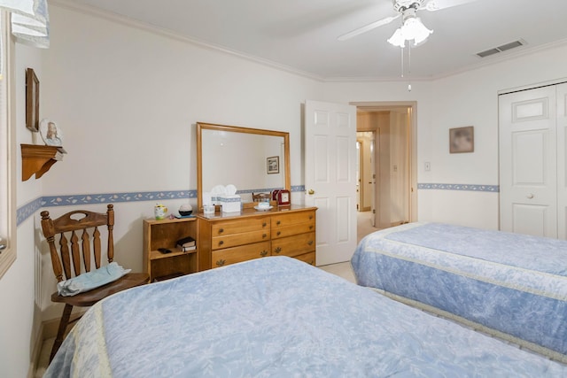 bedroom with ornamental molding, ceiling fan, and a closet