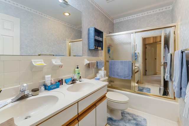 full bathroom featuring tile walls, toilet, vanity, and enclosed tub / shower combo