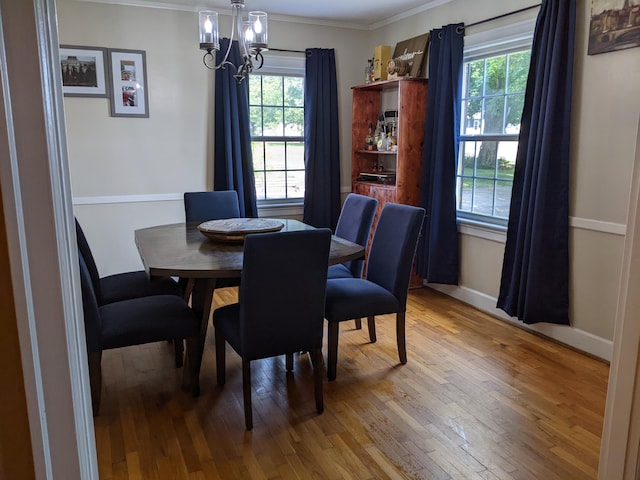 dining space with a notable chandelier, a wealth of natural light, and wood-type flooring