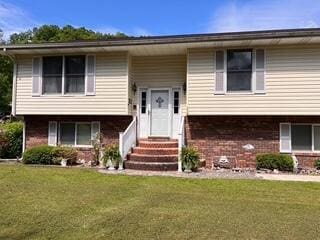 bi-level home with entry steps and a front lawn