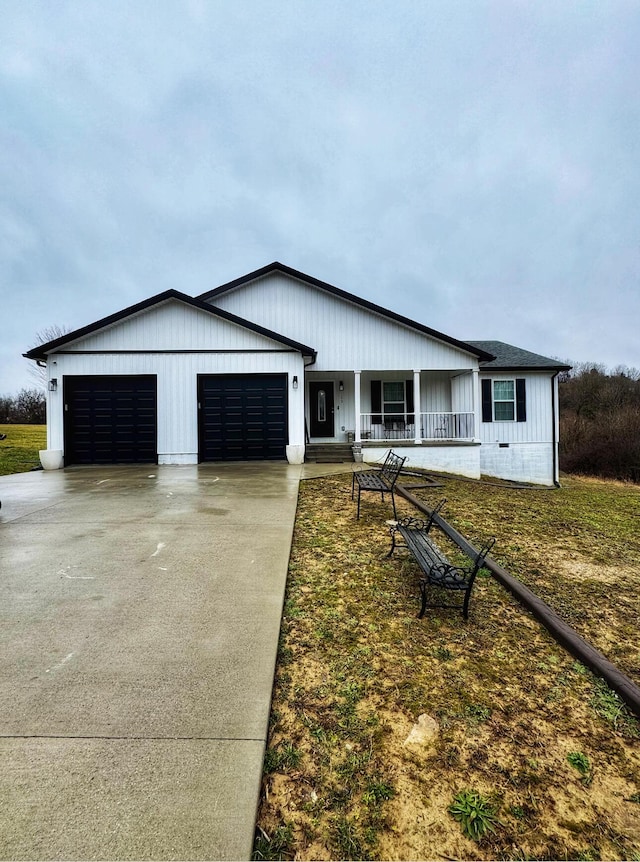 view of front of house featuring a porch, concrete driveway, and a garage