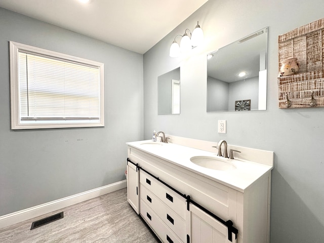 full bathroom with visible vents, wood finished floors, baseboards, and a sink
