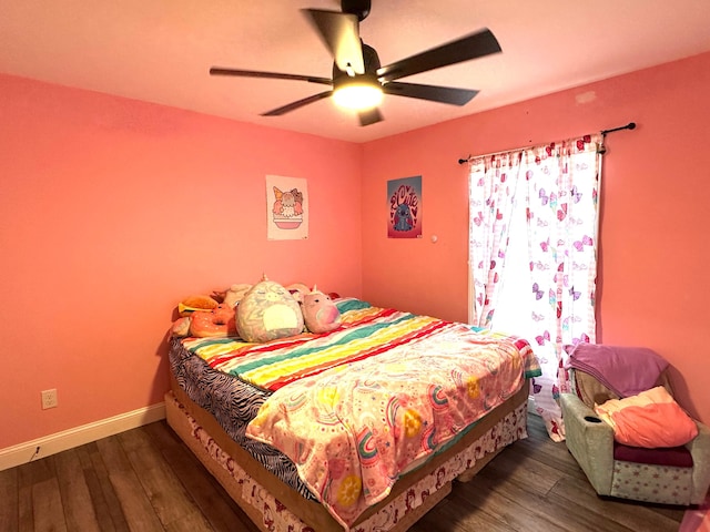 bedroom with a ceiling fan, baseboards, and wood-type flooring