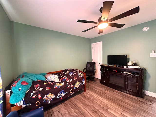 bedroom with ceiling fan, baseboards, and wood finished floors