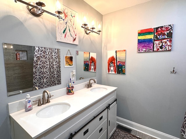 full bath featuring double vanity, visible vents, baseboards, and a sink