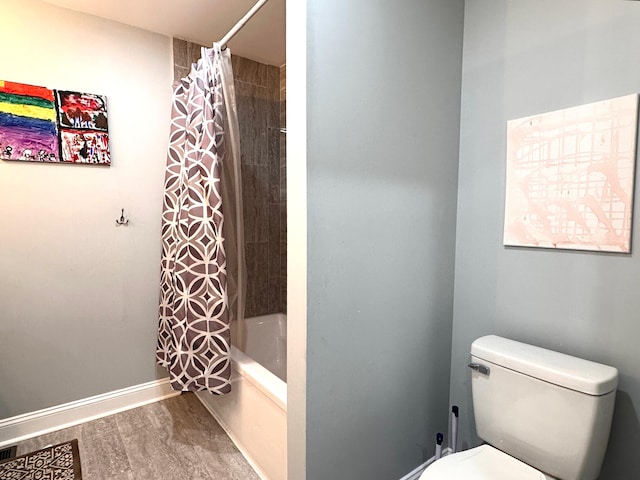 bathroom with toilet, shower / tub combo with curtain, baseboards, and wood finished floors