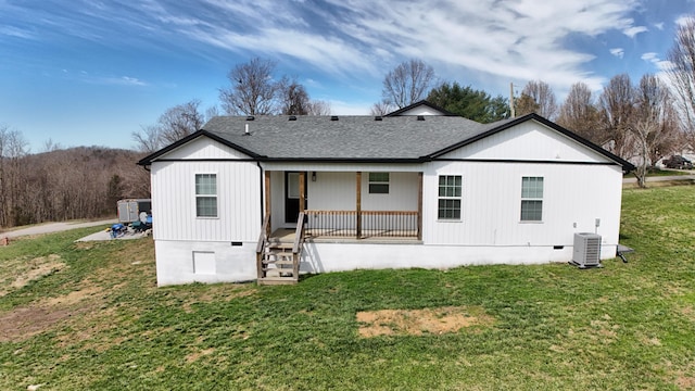 rear view of house with a lawn, cooling unit, covered porch, a shingled roof, and crawl space