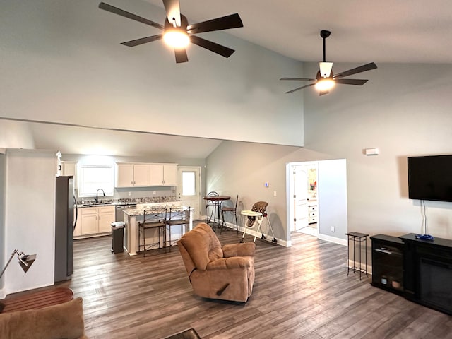 living area with baseboards, dark wood-type flooring, and ceiling fan