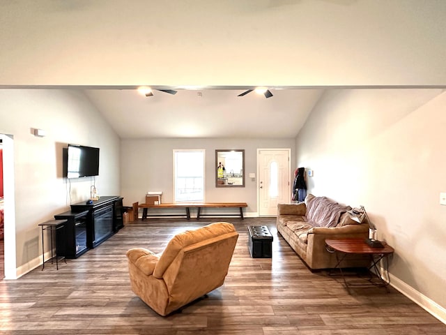 living area with baseboards, lofted ceiling, and wood finished floors
