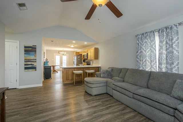 living room featuring lofted ceiling, ceiling fan with notable chandelier, and dark hardwood / wood-style flooring