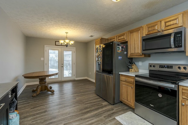 kitchen with a textured ceiling, appliances with stainless steel finishes, dark hardwood / wood-style flooring, a notable chandelier, and pendant lighting