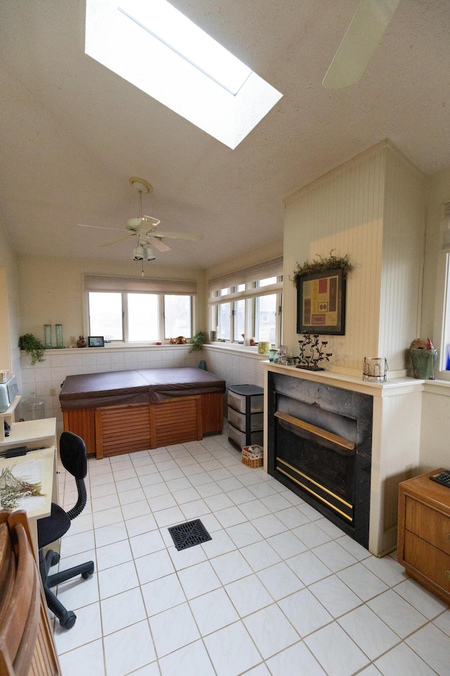 kitchen with kitchen peninsula, ceiling fan, and light tile patterned flooring