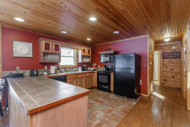 kitchen with sink, tile countertops, wooden ceiling, kitchen peninsula, and black appliances