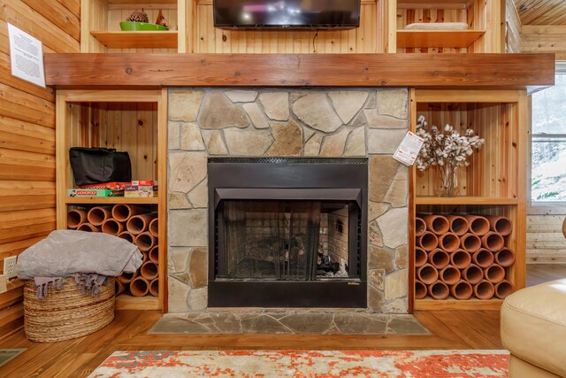 room details with a fireplace, wood-type flooring, and wooden walls