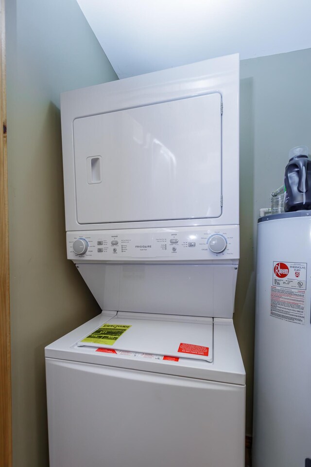 clothes washing area with water heater and stacked washing maching and dryer