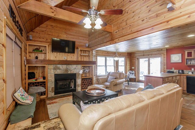 living room with wood ceiling, ceiling fan, vaulted ceiling with beams, a stone fireplace, and light wood-type flooring