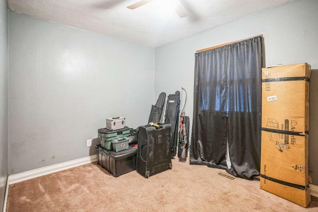 misc room featuring ceiling fan, carpet floors, and a textured ceiling