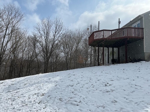 snowy yard featuring a wooden deck