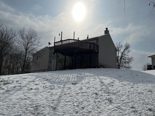 snow covered rear of property with a wooden deck